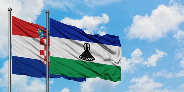 Bandera de Croacia y Lesotho ondeando en el viento contra el cielo azul nublado blanco juntos. Concepto diplomático, relaciones internacionales . — Foto de Stock