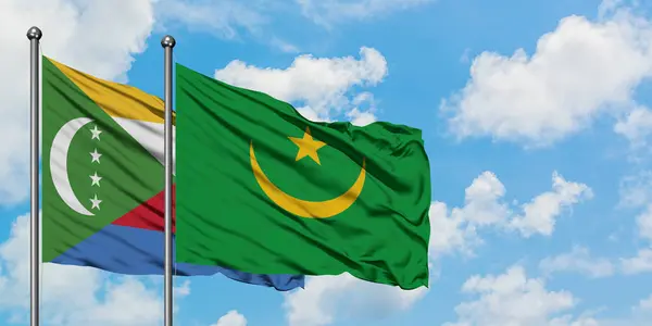 Bandera de Comoras y Mauritania ondeando en el viento contra el cielo azul nublado blanco juntos. Concepto diplomático, relaciones internacionales . — Foto de Stock