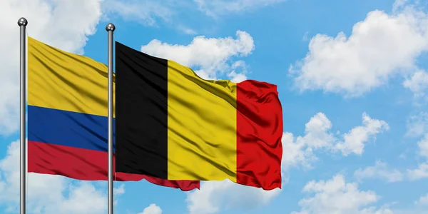 哥伦比亚和比利时国旗在风中飘扬，白云蓝天相聚。外交概念、国际关系. — 图库照片