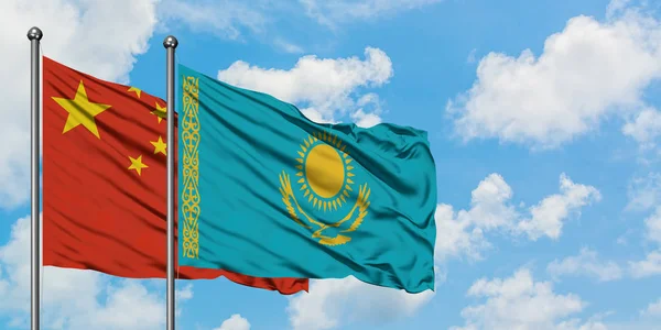 Китай и Казахстан вместе машут флагом на ветру против белого облачно-голубого неба. Концепция дипломатии, международные отношения . — стоковое фото