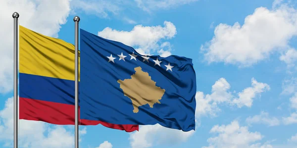 Колумбія і Косово прапор розмахував вітром проти білого хмарного синього неба разом. Концепція дипломатії, міжнародні відносини. — стокове фото