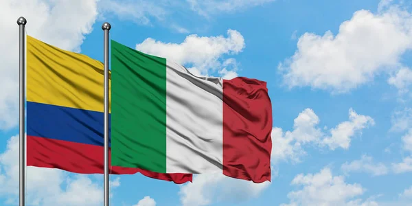 Bandera de Colombia e Italia ondeando en el viento contra el cielo azul nublado blanco juntos. Concepto diplomático, relaciones internacionales . — Foto de Stock