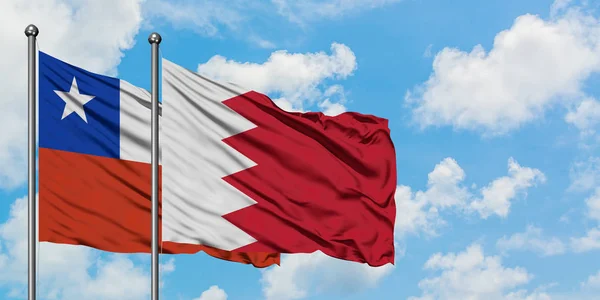Bandera de Chile y Bahréin ondeando en el viento contra el cielo azul nublado blanco juntos. Concepto diplomático, relaciones internacionales . — Foto de Stock
