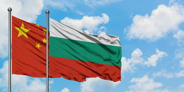 Kina og Bulgarien flag vinker i vinden mod hvid overskyet blå himmel sammen. Diplomati koncept, internationale relationer . - Stock-foto