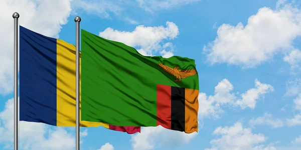 Drapeau du Tchad et de la Zambie agitant dans le vent contre ciel bleu nuageux blanc ensemble. Concept de diplomatie, relations internationales . — Photo