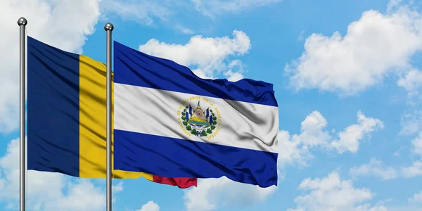 Bandera de Chad y El Salvador ondeando en el viento contra el cielo azul nublado blanco juntos. Concepto diplomático, relaciones internacionales . — Foto de Stock