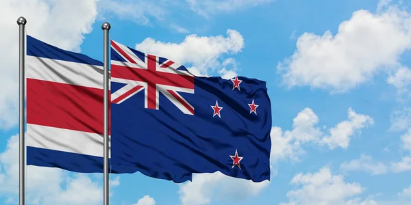 哥斯达黎加和新西兰国旗在风中飘扬，与白云蓝天相一起。外交概念、国际关系. — 图库照片