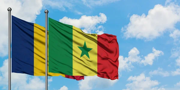 Bandera de Chad y Senegal ondeando en el viento contra el cielo azul nublado blanco juntos. Concepto diplomático, relaciones internacionales . — Foto de Stock