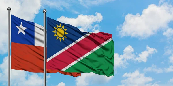 Chili en Namibië vlag zwaaien in de wind tegen witte bewolkte blauwe hemel samen. Diplomatie concept, internationale betrekkingen. — Stockfoto