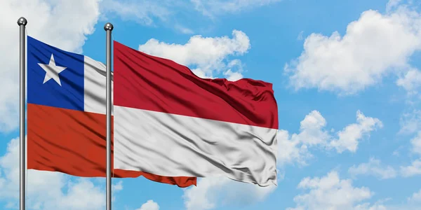 Chile a Indonésie vlají ve větru proti bíle zatažené modré obloze. Diplomacie, mezinárodní vztahy. — Stock fotografie