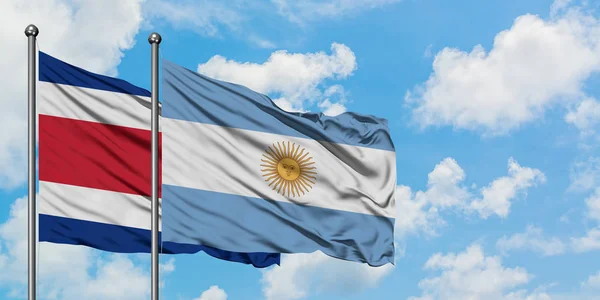 코스타리카와 아르헨티나 국기가 함께 하얀 흐린 푸른 하늘에 대해 바람에 흔들리고 있습니다. 외교 개념, 국제 관계. — 스톡 사진