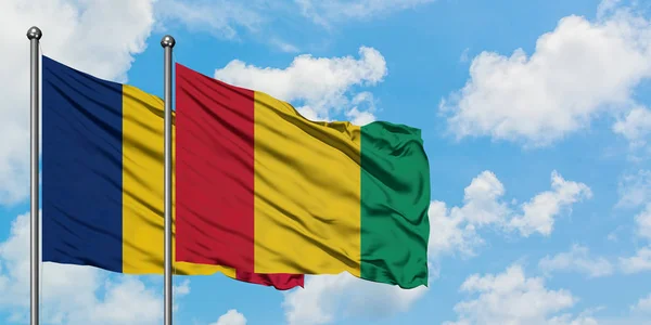 Bandera de Chad y Guinea ondeando en el viento contra el cielo azul nublado blanco juntos. Concepto diplomático, relaciones internacionales . — Foto de Stock
