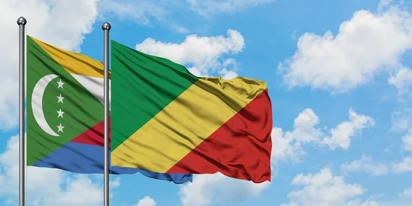 Bandera de las Comoras y República del Congo ondeando en el viento contra el cielo azul nublado blanco juntos. Concepto diplomático, relaciones internacionales . — Foto de Stock