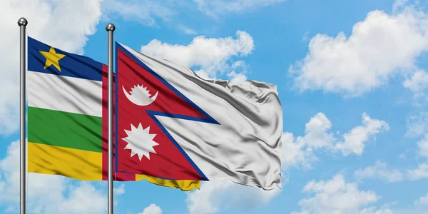 Bandera de la República Centroafricana y Nepal ondeando en el viento contra el cielo azul nublado blanco juntos. Concepto diplomático, relaciones internacionales . — Foto de Stock