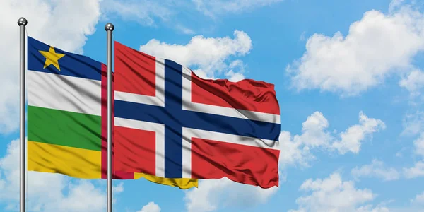 Bandera de la República Centroafricana y Noruega ondeando en el viento contra el cielo azul nublado blanco juntos. Concepto diplomático, relaciones internacionales . — Foto de Stock