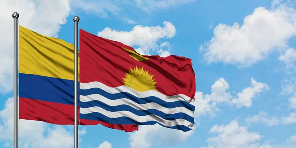 Bandera de Colombia y Kiribati ondeando en el viento contra el cielo azul nublado blanco juntos. Concepto diplomático, relaciones internacionales . — Foto de Stock