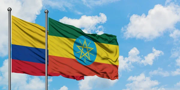 Colombia and Ethiopia flag waving in the wind against white cloudy blue sky together. Diplomacy concept, international relations. — Stock Photo, Image