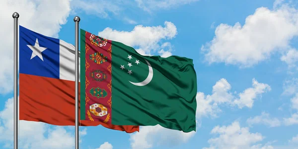 Bandera de Chile y Turkmenistán ondeando en el viento contra el cielo azul nublado blanco juntos. Concepto diplomático, relaciones internacionales . — Foto de Stock