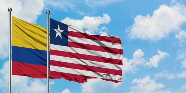 Colombia och Liberia flagga viftande i vinden mot vit grumlig blå himmel tillsammans. Diplomatisk koncept, internationella relationer. — Stockfoto