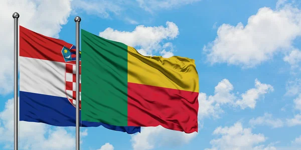 Chorvatsko a Benin praporce mávali ve větru proti bíle zatažené modré obloze. Diplomacie, mezinárodní vztahy. — Stock fotografie