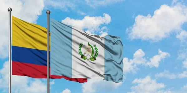 Η σημαία της Κολομβίας και της Γουατεμάλας κουνώντας τον άνεμο εναντίον του λευκού νεφελού γαλάζιου ουρανού μαζί. Φιλοσοφία της διπλωματίας, διεθνείς σχέσεις. — Φωτογραφία Αρχείου