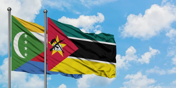 一緒に白い曇り青い空に対して風に手を振るコモロとモザンビークの旗。外交概念、国際関係. — ストック写真