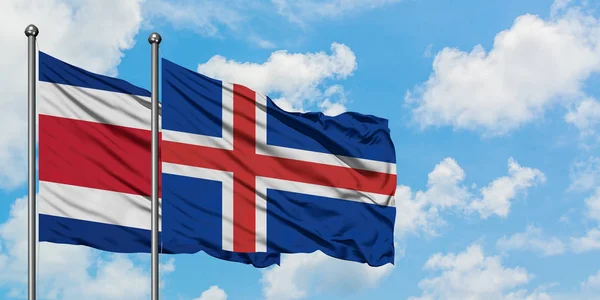 Bandera de Costa Rica e Islandia ondeando en el viento contra el cielo azul nublado blanco juntos. Concepto diplomático, relaciones internacionales . —  Fotos de Stock