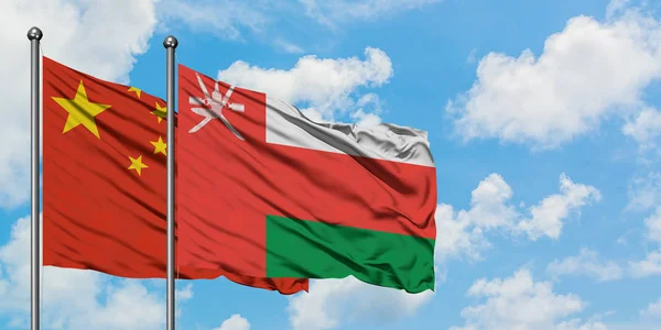 Kina og Oman flag vinker i vinden mod hvid overskyet blå himmel sammen. Diplomati koncept, internationale relationer . - Stock-foto