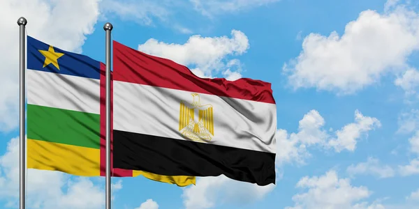 Bandera de la República Centroafricana y Egipto ondeando en el viento contra el cielo azul nublado blanco juntos. Concepto diplomático, relaciones internacionales . — Foto de Stock