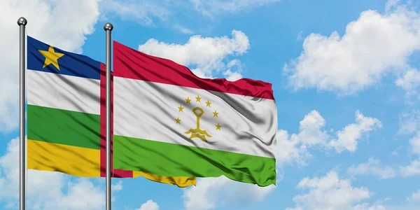 Bandera de República Centroafricana y Tayikistán ondeando en el viento contra el cielo azul nublado blanco juntos. Concepto diplomático, relaciones internacionales . — Foto de Stock