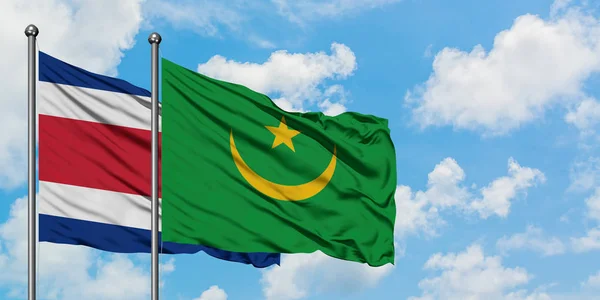 Bandera de Costa Rica y Mauritania ondeando en el viento contra el cielo azul nublado blanco juntos. Concepto diplomático, relaciones internacionales . — Foto de Stock