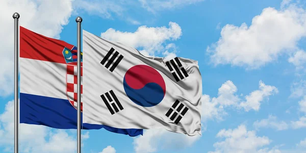 Hırvatistan ve Güney Kore bayrağı birlikte beyaz bulutlu mavi gökyüzüne karşı rüzgarsal sallayarak. Diplomasi kavramı, uluslararası ilişkiler. — Stok fotoğraf