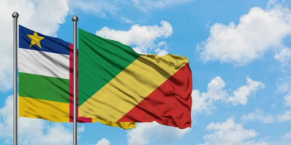 Bandera de República Centroafricana y República del Congo ondeando en el viento contra el cielo azul nublado blanco juntos. Concepto diplomático, relaciones internacionales . — Foto de Stock