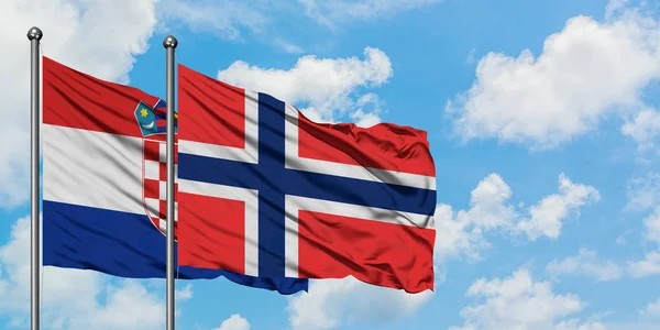 Bandera de Croacia y Bouvet Islands ondeando en el viento contra el cielo azul nublado blanco juntos. Concepto diplomático, relaciones internacionales . —  Fotos de Stock