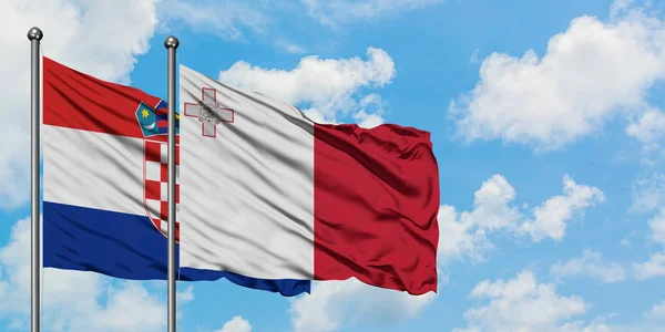 Chorvatsko a Malta vlají ve větru proti bíle zatažené modré obloze. Diplomacie, mezinárodní vztahy. — Stock fotografie