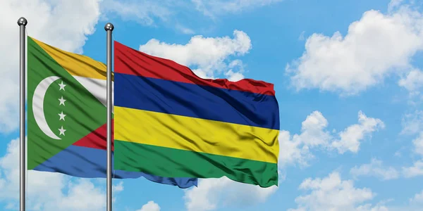 Bandera de Comoras y Mauricio ondeando en el viento contra el cielo azul nublado blanco juntos. Concepto diplomático, relaciones internacionales . — Foto de Stock