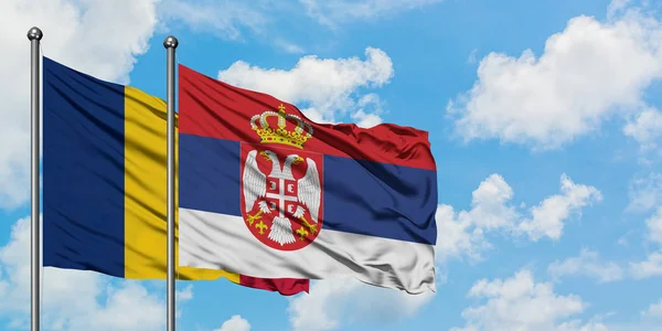 Bandera de Chad y Serbia ondeando en el viento contra el cielo azul nublado blanco juntos. Concepto diplomático, relaciones internacionales . — Foto de Stock