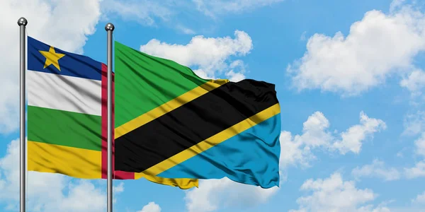 República Centro-Africana e a bandeira da Tanzânia agitando no vento contra o céu azul nublado branco juntos. Conceito de diplomacia, relações internacionais . — Fotografia de Stock