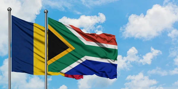 Chade e a bandeira da África do Sul agitando no vento contra o céu azul nublado branco juntos. Conceito de diplomacia, relações internacionais . — Fotografia de Stock