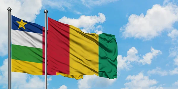 Bandera de la República Centroafricana y Guinea ondeando en el viento contra el cielo azul nublado blanco juntos. Concepto diplomático, relaciones internacionales . — Foto de Stock