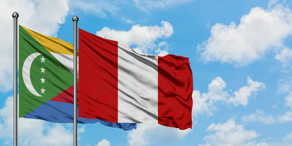 Bandera de Comoras y Perú ondeando en el viento contra el cielo azul nublado blanco juntos. Concepto diplomático, relaciones internacionales . — Foto de Stock