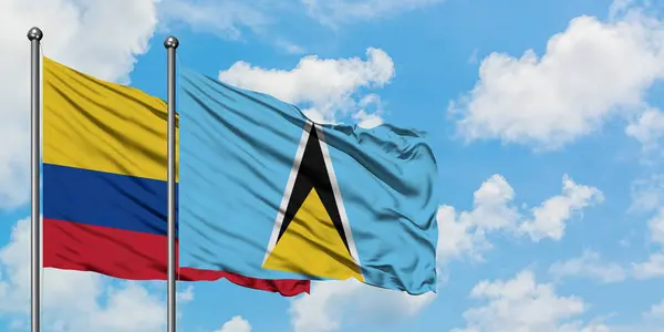 Η Κολομβία και η σημαία της Αγίας Λουτσίας χαιρετάνε τον άνεμο εναντίον του λευκού νεφελούχου γαλάζιου ουρανού. Φιλοσοφία της διπλωματίας, διεθνείς σχέσεις. — Φωτογραφία Αρχείου