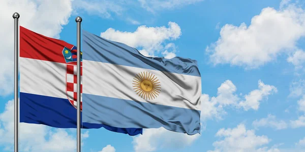 Bandera de Croacia y Argentina ondeando en el viento contra el cielo azul nublado blanco juntos. Concepto diplomático, relaciones internacionales . — Foto de Stock