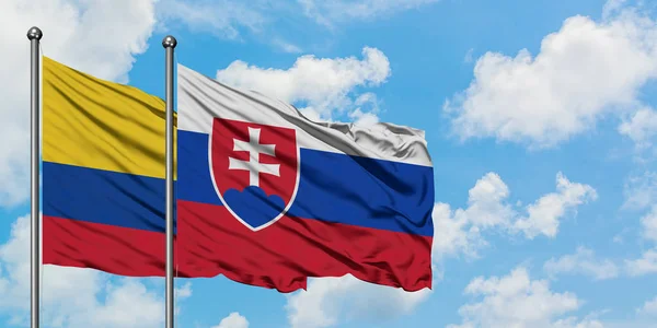 Colombia och Slovakien flagga vifta i vinden mot vit grumlig blå himmel tillsammans. Diplomatisk koncept, internationella relationer. — Stockfoto
