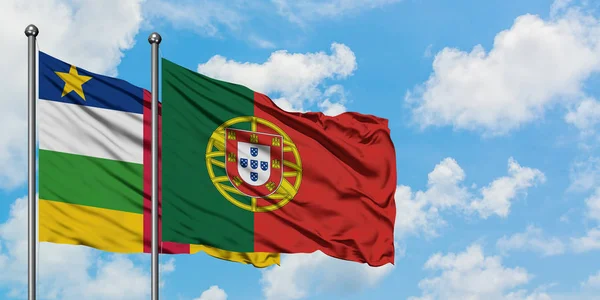 Bandeira da República Centro-Africana e de Portugal agitando no vento contra o céu azul nublado branco juntos. Conceito de diplomacia, relações internacionais . — Fotografia de Stock