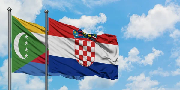 Bandera de las Comoras y Croacia ondeando en el viento contra el cielo azul nublado blanco juntos. Concepto diplomático, relaciones internacionales . — Foto de Stock