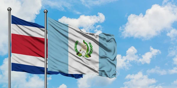 Bandera de Costa Rica y Guatemala ondeando en el viento contra el cielo azul nublado blanco juntos. Concepto diplomático, relaciones internacionales . — Foto de Stock