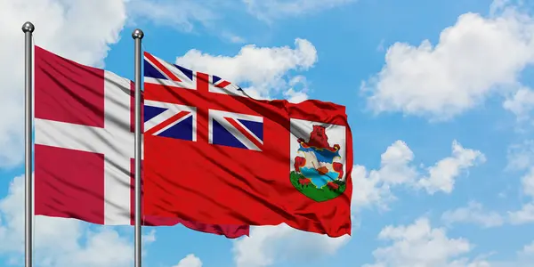 Bandera de Dinamarca y Bermudas ondeando en el viento contra el cielo azul nublado blanco juntos. Concepto diplomático, relaciones internacionales . — Foto de Stock