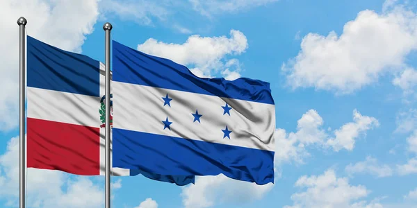 Bandera de República Dominicana y Honduras ondeando en el viento contra el cielo azul nublado blanco juntos. Concepto diplomático, relaciones internacionales . — Foto de Stock