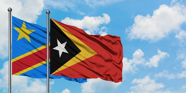 Bandera del Congo y Timor Oriental ondeando en el viento contra el cielo azul nublado blanco juntos. Concepto diplomático, relaciones internacionales . — Foto de Stock